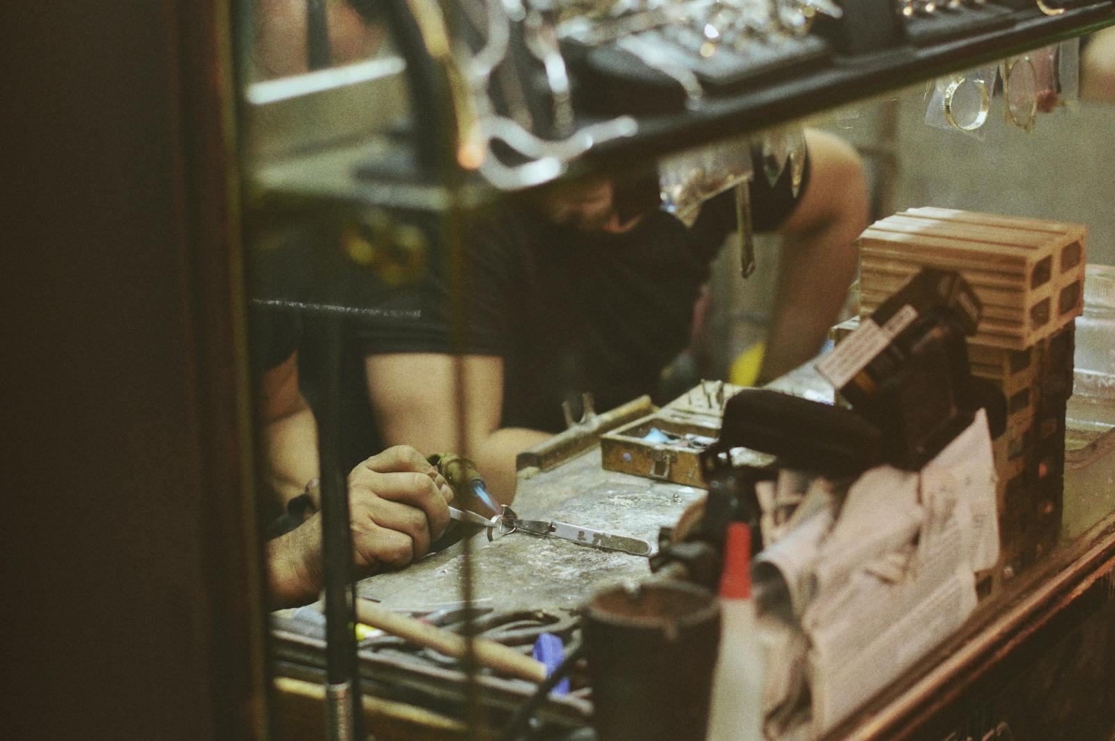 Close-up of an artisan at work in a jewelry workshop, focusing on craftsmanship and tools
