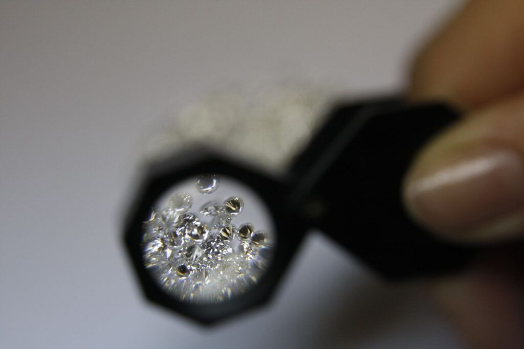 A jeweler's loupe magnifying a scatter of loose diamonds, evoking the close examination behind a 706-website industry study