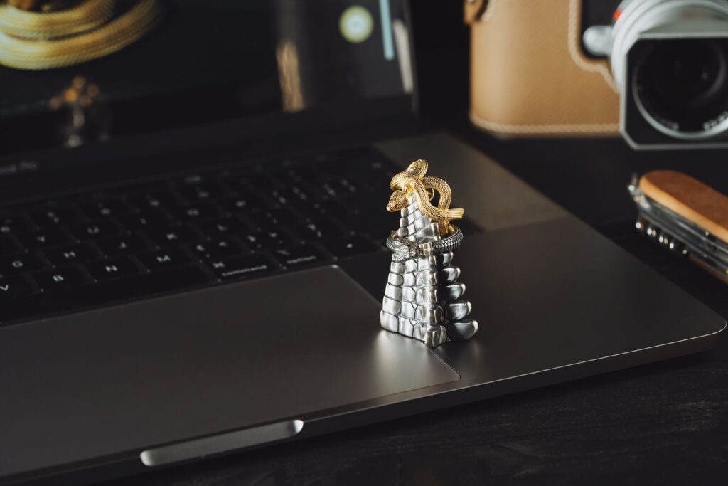 A gold and silver statement ring resting on a laptop keyboard, illustrating fine jewelry meeting the AI commerce surfaces where buyers now discover and purchase it
