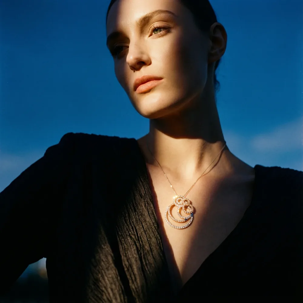 Woman in golden evening light wearing a diamond swirl pendant necklace